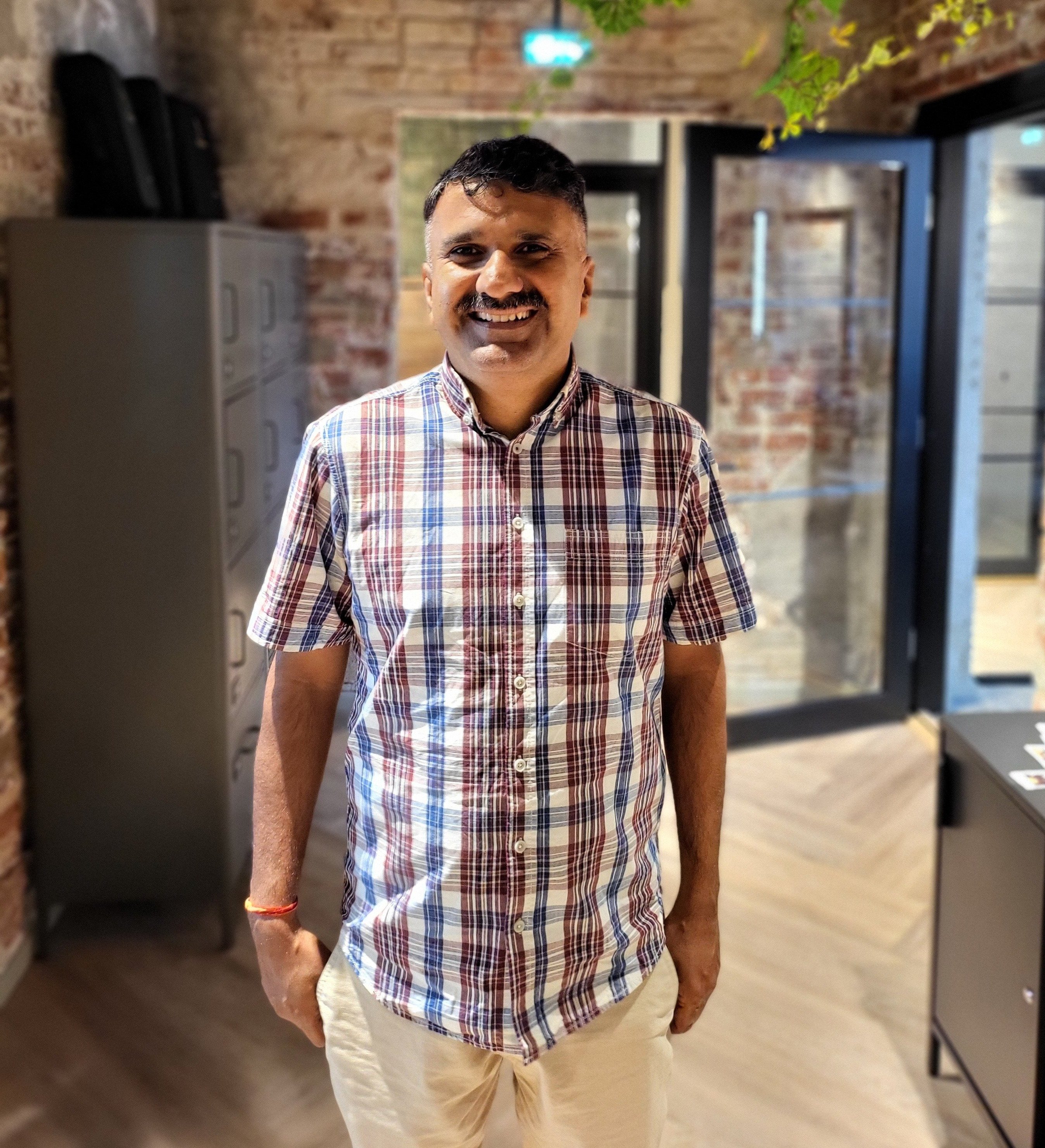 Lars sitter på tribunen foran en bspoke logo